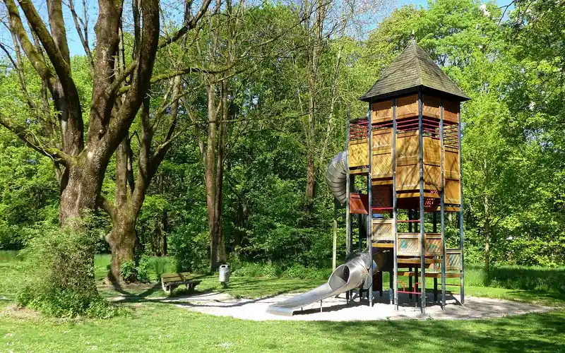 Tall wooden playset tower built from natural cedar-style posts and slide Tall wooden playset tower built from natural cedar-style posts and slide