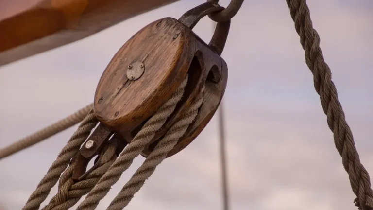 Antique wooden pulley block with a rope running over the sheave