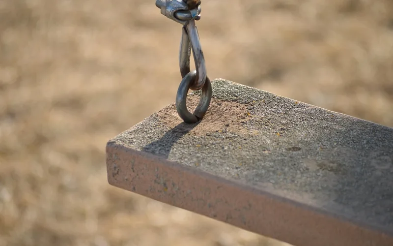 Close-up of a swing chain hook bolted into a weathered wood beam Close-up of a swing chain hook bolted into a weathered wood beam