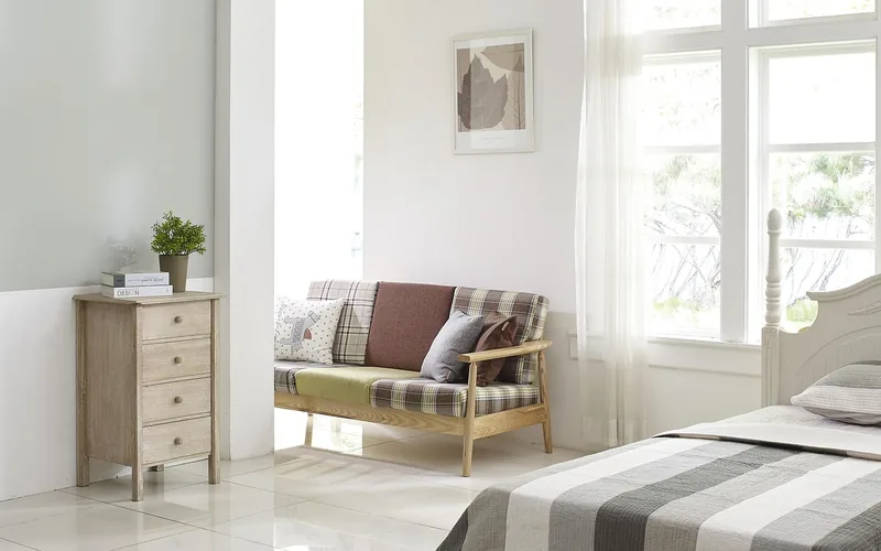 bedroom with open window and sheer curtains for ventilation