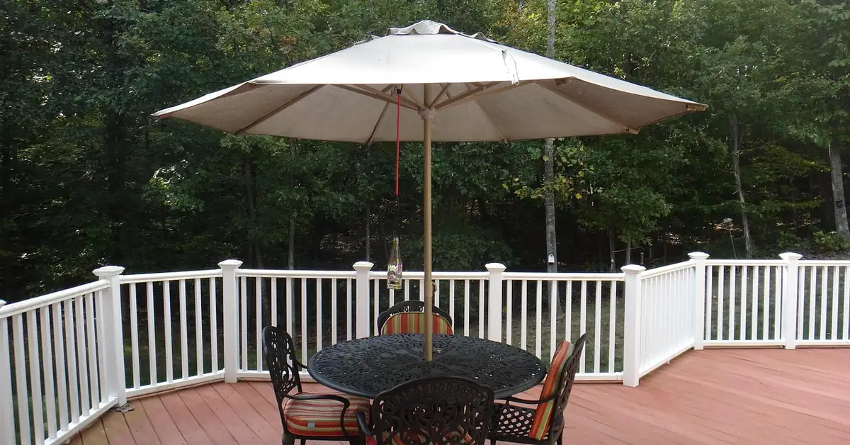 Wraparound composite deck with white railing and outdoor dining furniture Wraparound composite deck with white railing and outdoor dining furniture