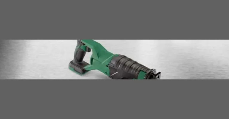 Cordless compact reciprocating saw resting on a workbench, brushless motor housing and pivoting shoe visible
