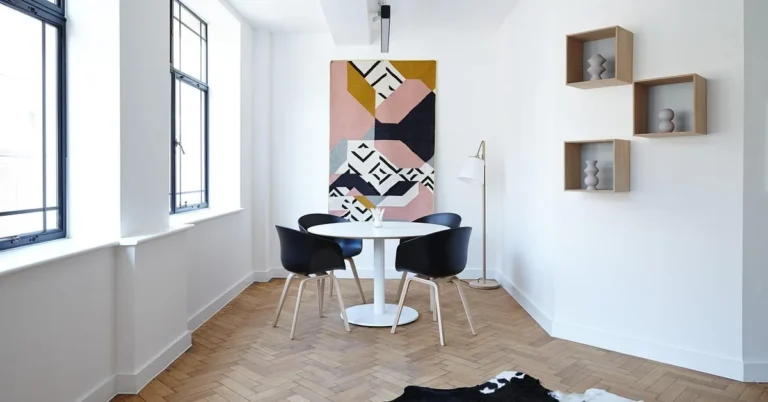 Wooden dining table and chairs on a herringbone parquet wood floor