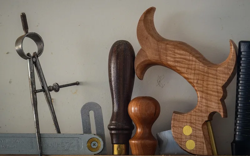 Traditional hand saw with wooden handle resting on a sawn workbench