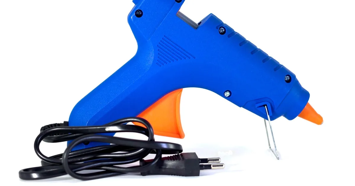 Blue hot glue gun with full-size glue sticks loaded, used for crafts and woodworking jigs