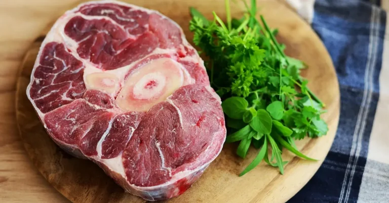 Raw meat resting on a wood cutting board before cleaning and sanitizing