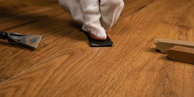 Sanding a filled nick in a hardwood floor smooth before staining