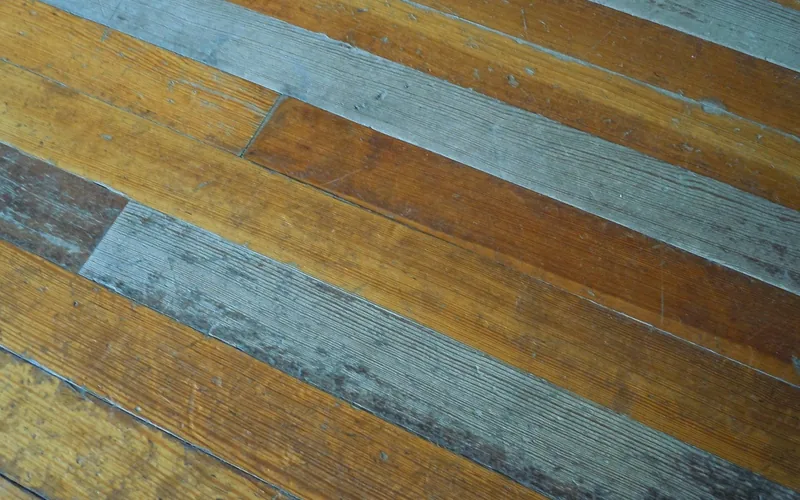 close-up of wood floor planks showing stains and scratches from wear close-up of wood floor planks showing stains and scratches from wear