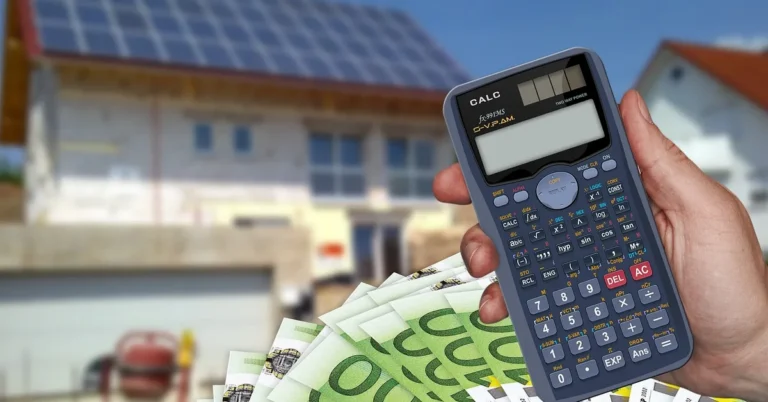 Hand holding a calculator with cash in front of a house under construction for building cost estimation