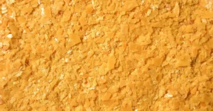 Yellow carnauba wax flakes, a hard natural wax used in many paste waxes