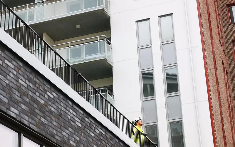 Deck builder installing composite decking boards and railings on a home deck