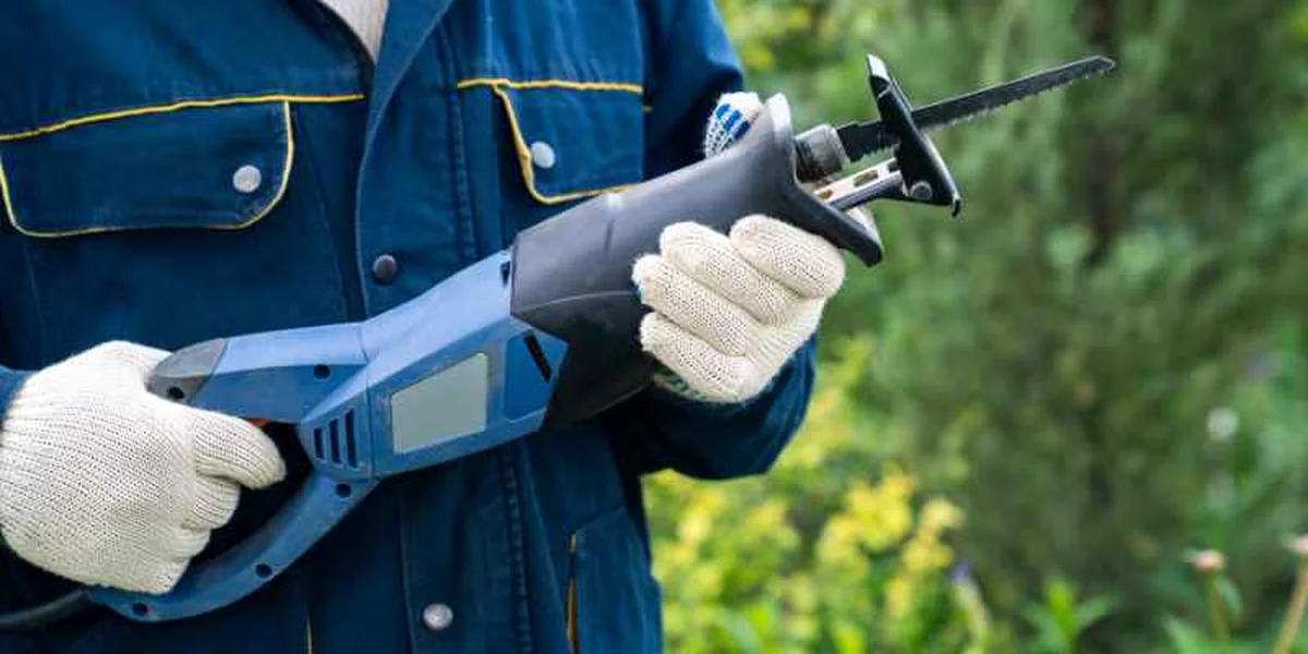 Cordless reciprocating saw being used outdoors, comparable to Harbor Freight Warrior, Bauer, and Hercules models