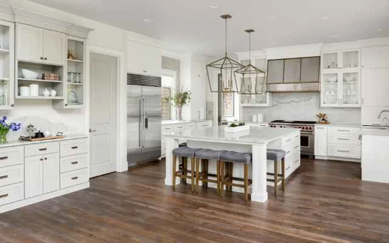 dark stained hardwood floor in a modern kitchen with white cabinets
