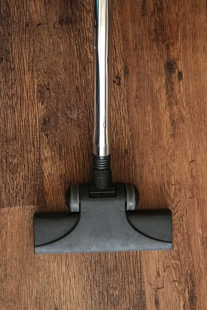 Vacuum hard-floor attachment head with hose on a hardwood floor