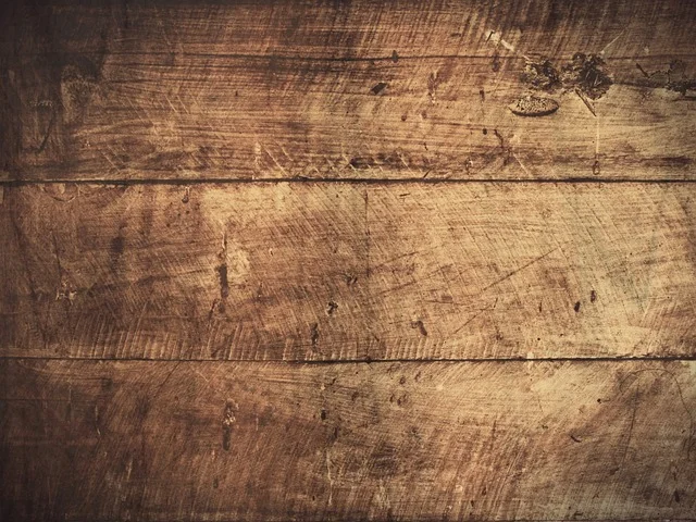 Close-up of a hardwood floor surface with deep scratches and worn finish