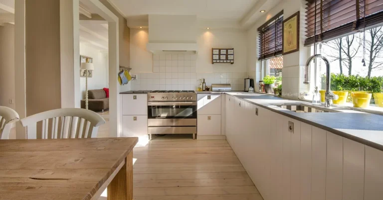 Bright kitchen with a light hardwood plank floor and white cabinets