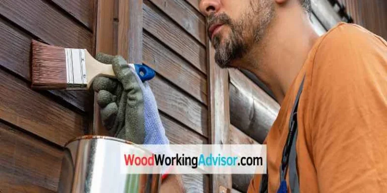 Applying wood stain to exterior siding with a paintbrush