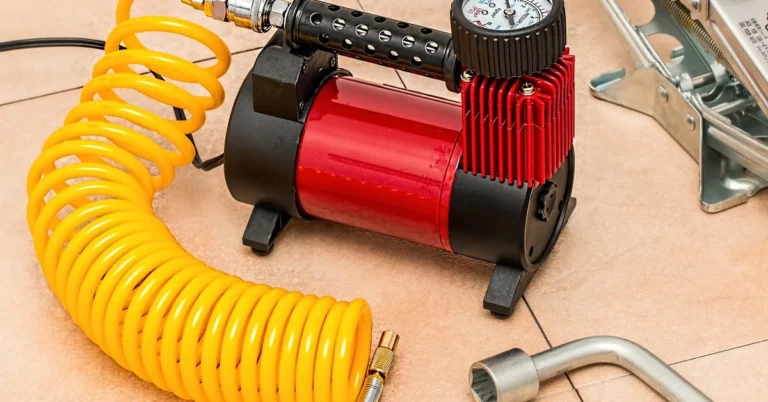Air compressor with coiled hose and pressure gauge attached, ready to power pneumatic shop tools