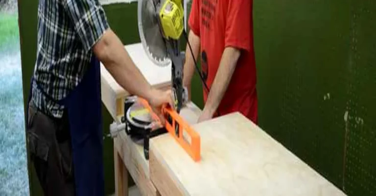 Two people assembling a DIY miter saw stand from 2x4 lumber on a plywood workbench