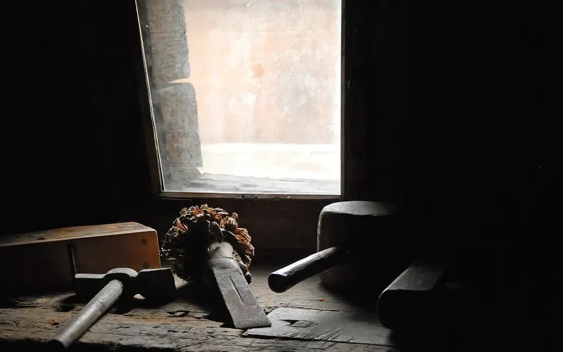 Old hand tools on a workshop bench by a window