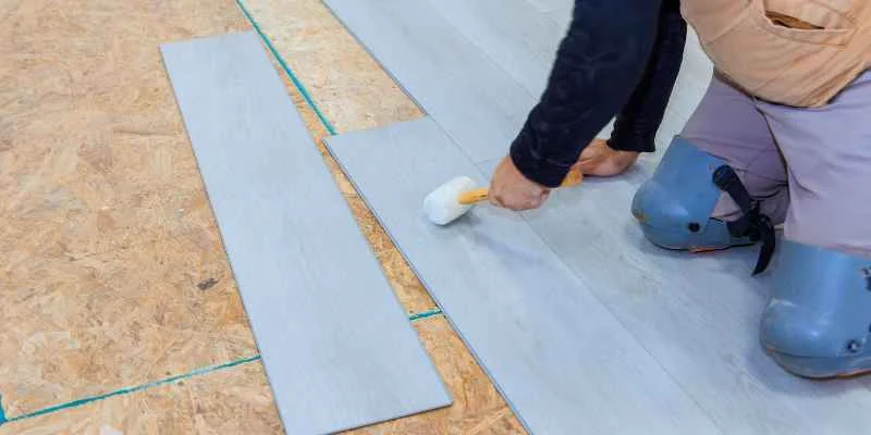 Laying a peel-and-stick vinyl plank onto a prepared OSB subfloor