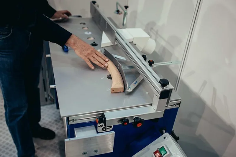 Close-up of a table saw insert plate area with a workpiece being fed across it