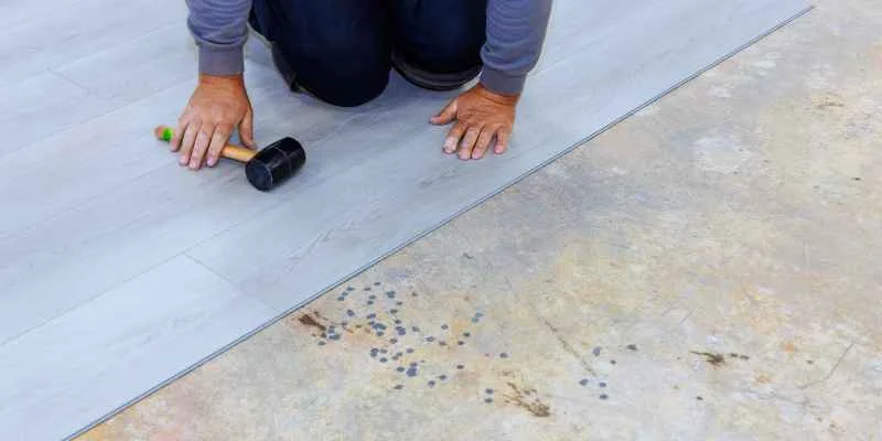 Setting a vinyl plank into place with a rubber mallet during installation