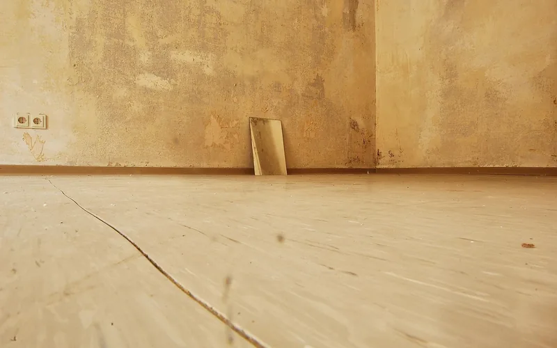 Worn, cracked wood subfloor boards showing visible damage that signals a floor needs refinishing Worn, cracked wood subfloor boards showing visible damage that signals a floor needs refinishing