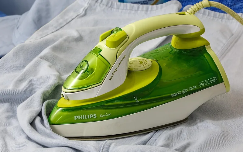 ironing a garment on an ironing board using low heat with a press cloth
