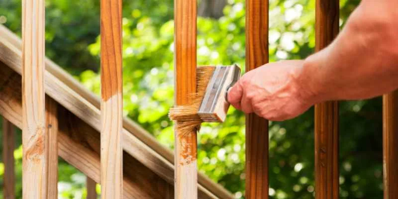 Applying wood oil to a wood surface Applying wood oil with a cloth to a wood surface, working the finish with the grain