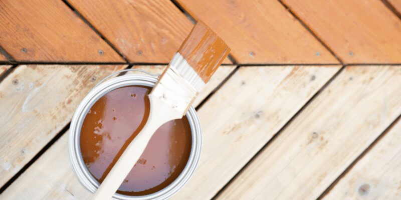 close-up of a putty knife smoothing wood filler into a repair before staining