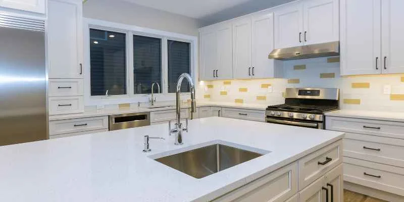 finished white laminate kitchen countertop with stainless sink and faucet