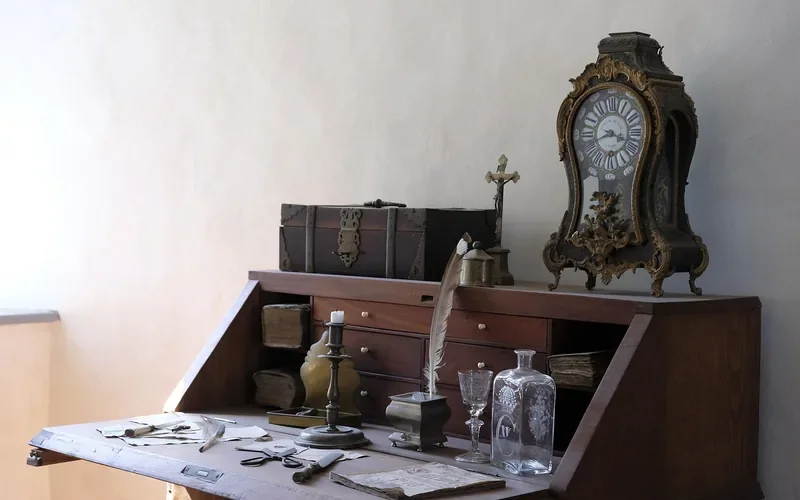 antique mahogany secretary desk with decorative clock, showing a well-preserved finish