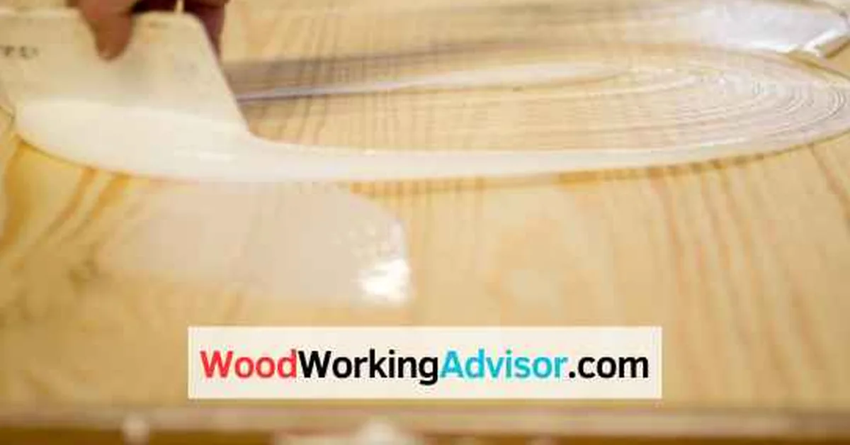 Spreading adhesive evenly across a wood surface before attaching fabric