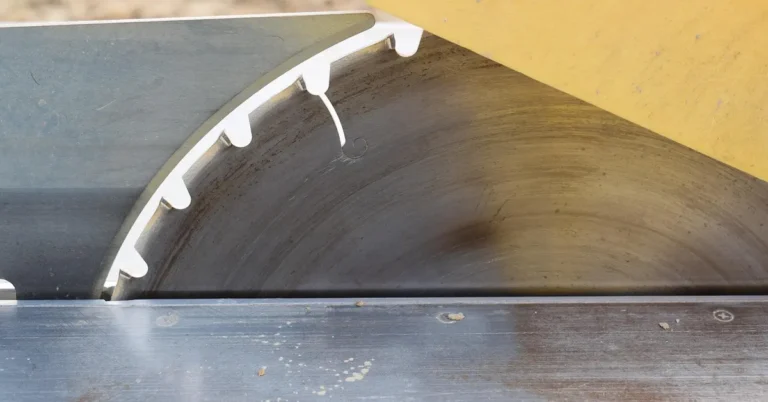 Cast iron table saw top surface with light rust near the blade
