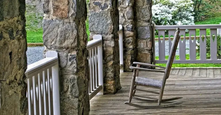 weathered solid cedar wood rocking chair on a wooden porch deck