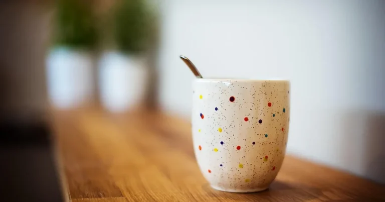 ceramic mug sitting directly on an unprotected wood table, the way water rings usually start