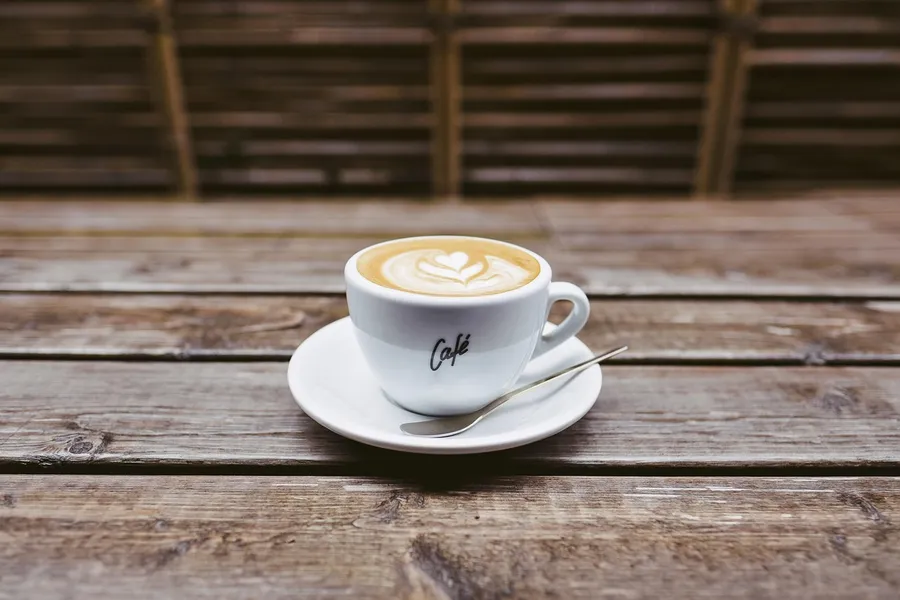 Coffee cup on a wooden table where a coaster prevents heat and moisture damage Coffee cup on a wooden table where a coaster prevents heat and moisture damage