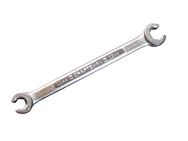 Close-up of a combination wrench sized for a table saw arbor nut