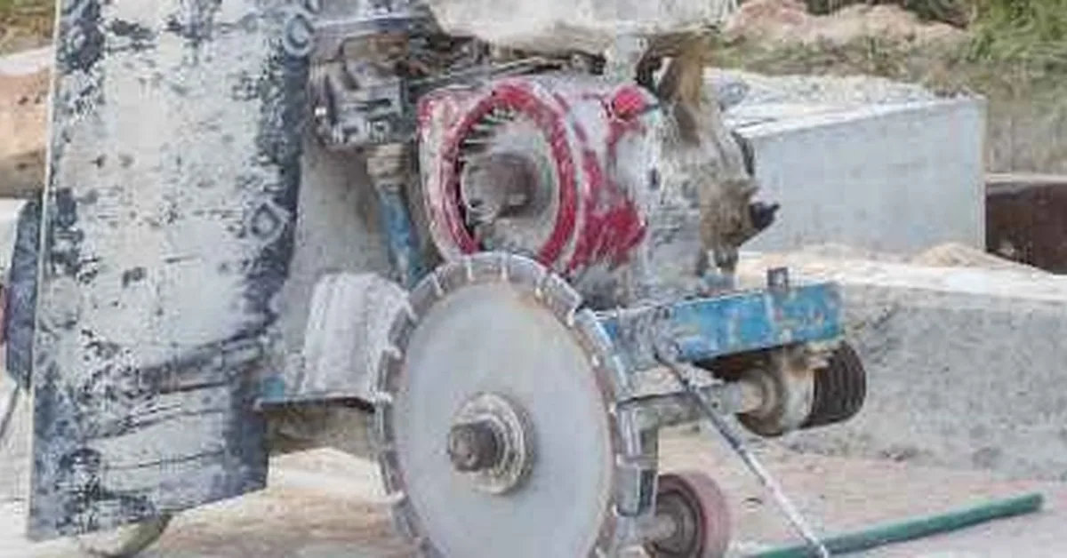 Walk-behind diamond blade concrete saw cutting a control joint into a fresh slab at a job site