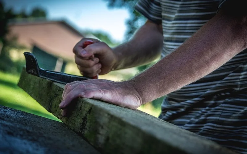 Woodworker using a hand plane while wearing shop gear Woodworker using a hand plane while wearing shop gear