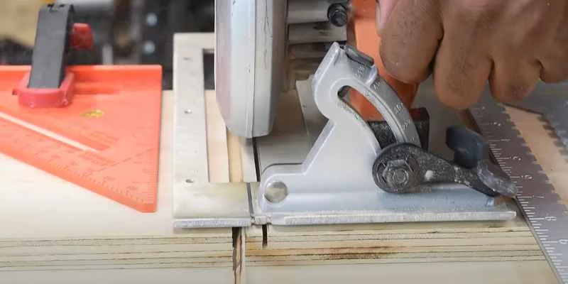 Circular saw making a kerf cut guided by a speed square into a board to start a dado joint