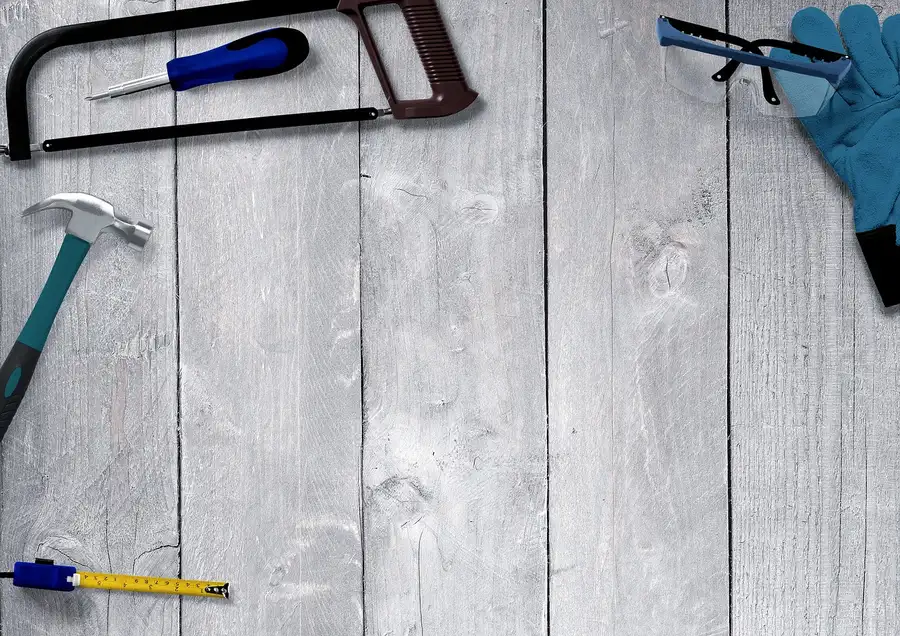 Safety goggles and gloves laid out next to metal cutting tools for Dremel steel work