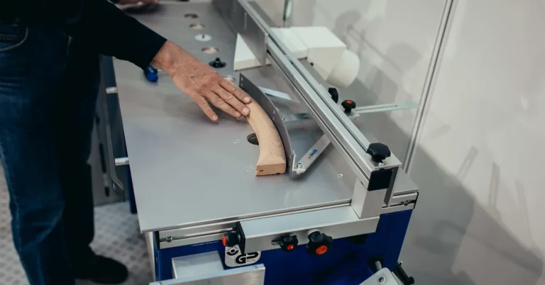 stationary woodworking machine feeding a wood board in a home workshop