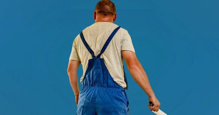 Professional painter holding a roller pole before starting a wall-painting job