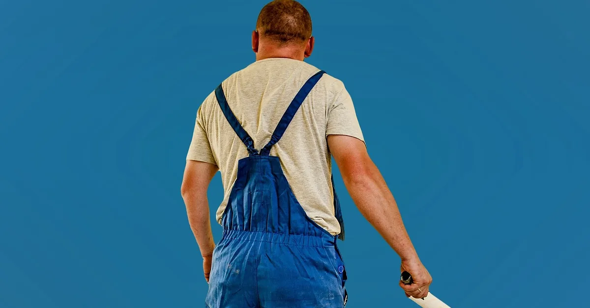 Professional painter holding a roller pole before starting a wall-painting job