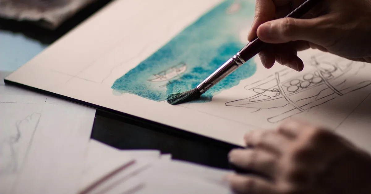 Artist hand painting with brush and non-toxic acrylic-based paint, illustrating the pigment types used in fabric paint