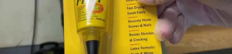 Minwax stainable wood filler tube held next to package, close-up of latex wood filler product