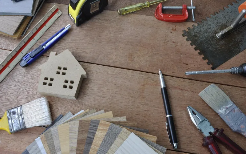 Flooring repair tools and plank color samples laid out for a gap repair job