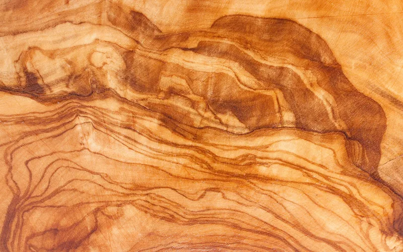 Oiled olive wood cutting board grain close up, the recommended surface for direct food cutting instead of epoxy